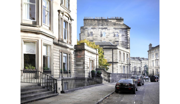 a large, grand house with cars parked outside