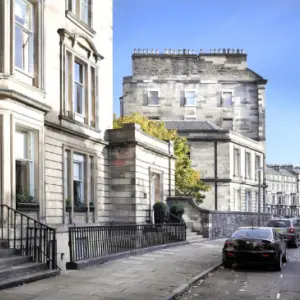 a large, grand house with cars parked outside