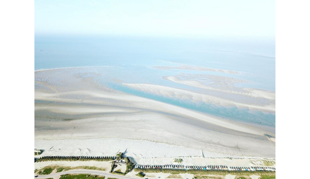 an aerial view of a sandy beach at low tide
