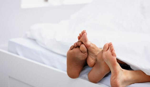 Couples feet in bed