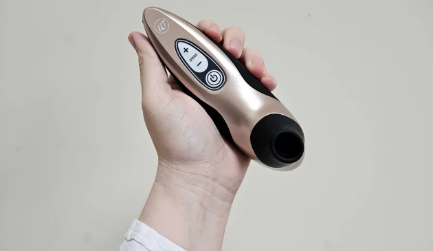 A Mumsnet editor's hand holds the Womanizer X Lovehoney Pro40 sex toy against a cream wall