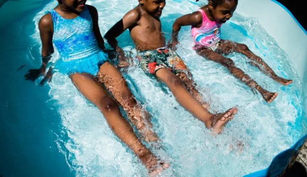 how to keep paddling pool water clean - 3 children playing in a paddling pool