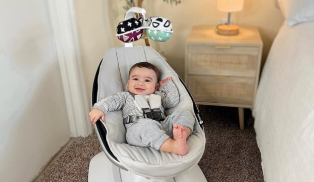 Baby laying in 4Moms MamaRoo baby swing in bedroom