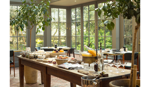 a breakfast buffet in a light, airy kitchen with floor to ceiling windows