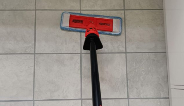 The Henry Spray Mop is tested on off-white laminate flooring. Only the mop head and part of the black handle is in shot.