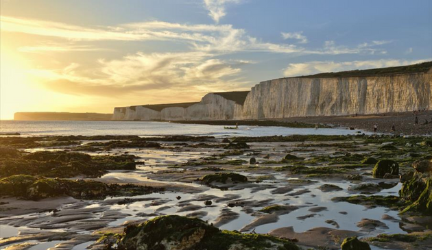 rockpools at sunset with chalk cliffs in the background