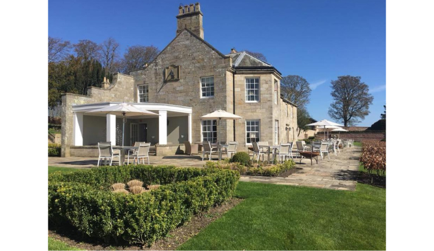 the outside of a stately hotel on a sunny day