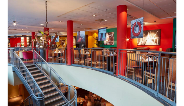 a brightly decorated hotel lobby with red pillars
