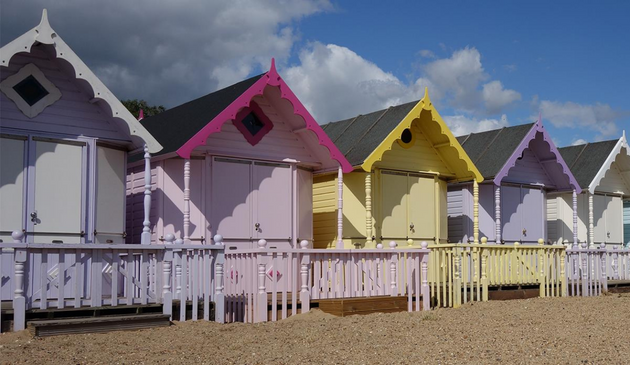 brightly coloured beach huts on an overcast day