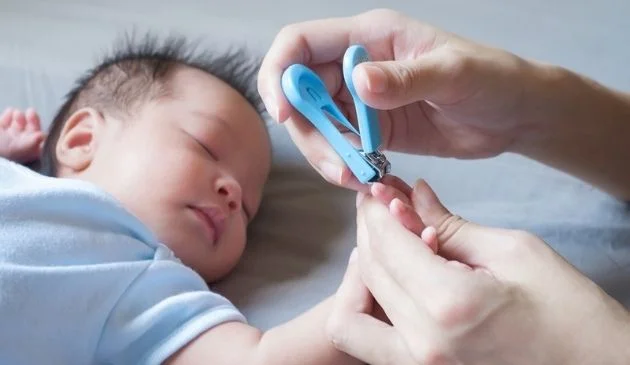 baby having nails trimmed while asleep