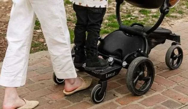 Woman walking with a child on a buggy board
