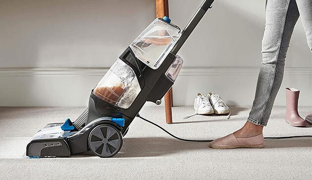Woman using Vax carpet cleaner