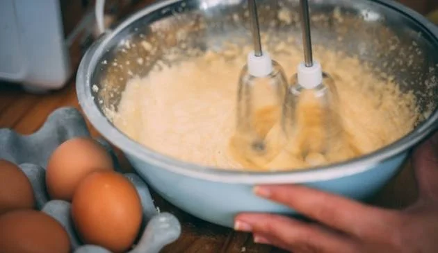 Woman using an electric whisk