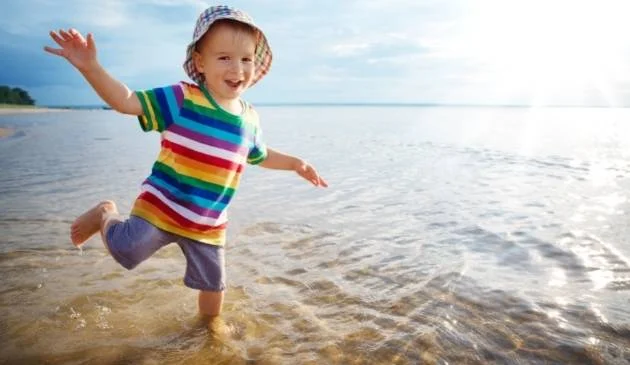 Child wearing a sun hat at the beach