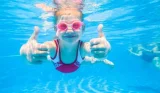 Child swimming underwater in a swimsuit