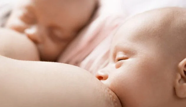 Mother breastfeeding two babies at the same time