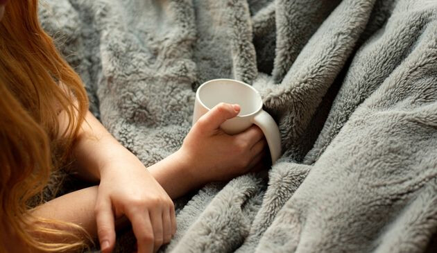 Blanket on woman on sofa