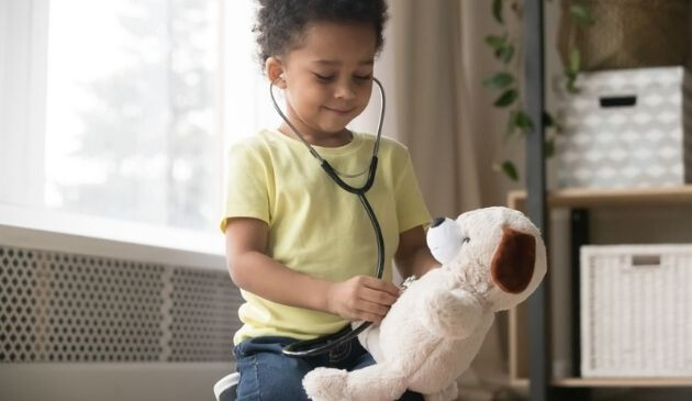 child playing doctors with teddy bear