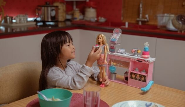 child playing restaurants with Barbie