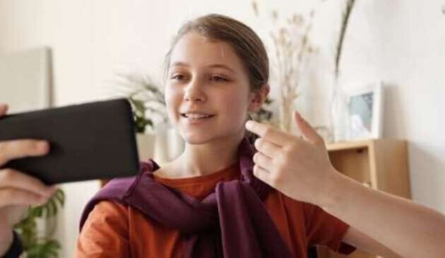 Teen girl pointing phone camera at herself