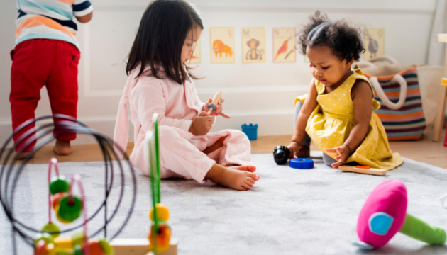 Three children playing with toys at nursery