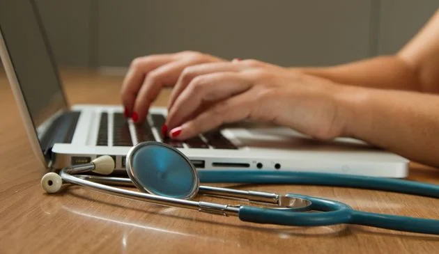 GP typing on laptop