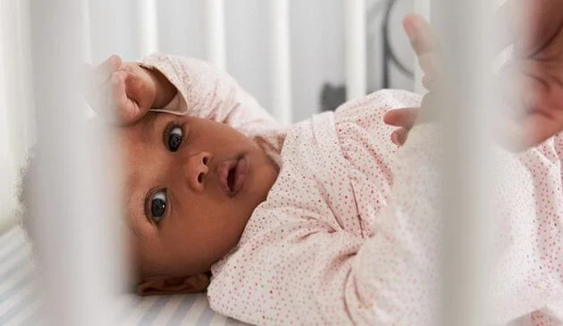 Baby lying in cot