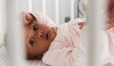 Baby lying in cot