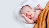 Cute newborn snuggled under a blanket