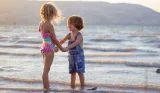 Toddlers holding hands in the sea
