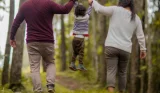 Young child lifted into the air by parents