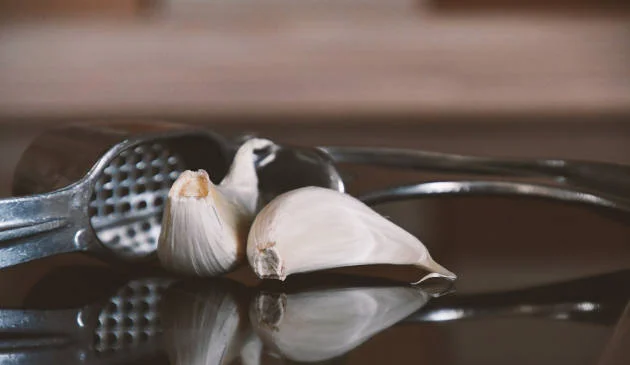 Garlic press and garlic cloves