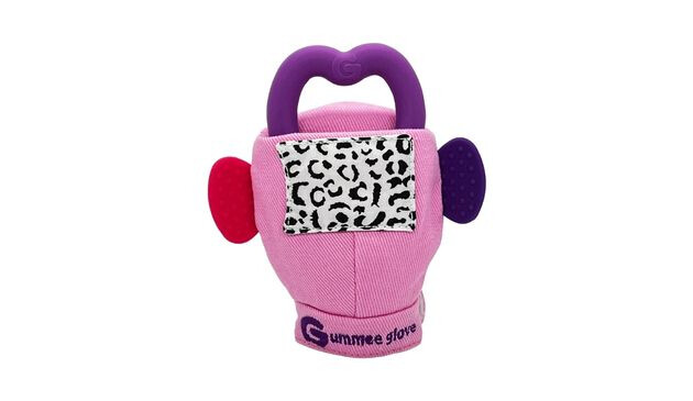 A pink teething glove with a purple heart-shaped teether ring on the top, a black and white patch on the front and two plastic ovals sticking out from either side