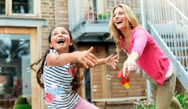 happy mum and daughter playing in garden