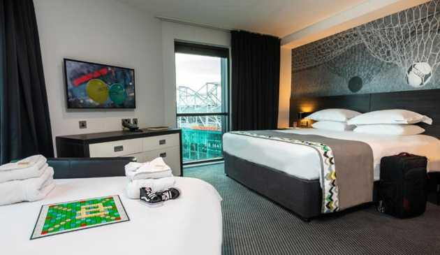 Beds in a room in Hotel Football with a window overlooking the stadium