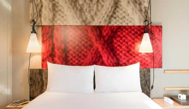 Room in Ibis hotel with bed, hanging lamps and wall decor