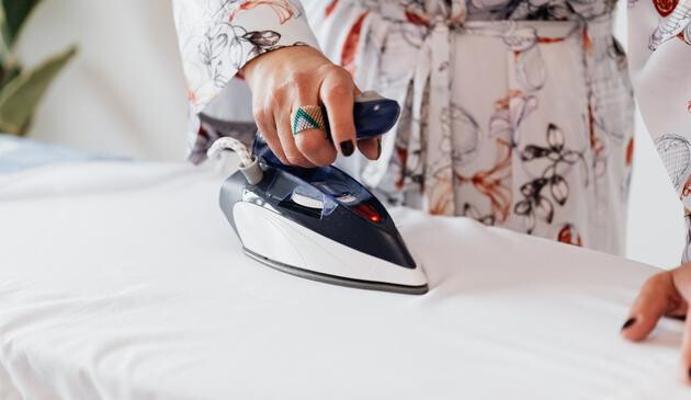 A picture of clothes being ironed on an ironing board.