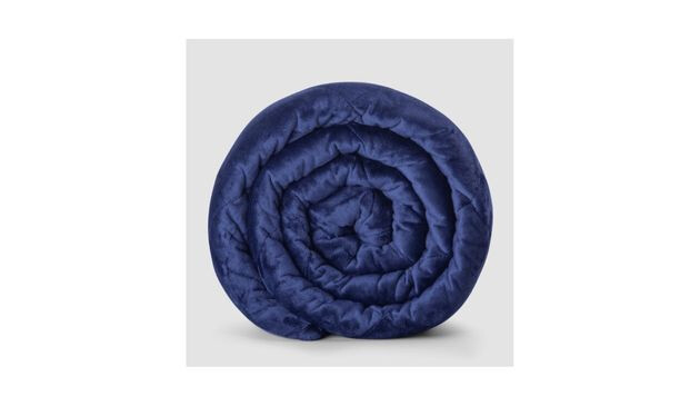 A dark blue weighted blanket rolled up and laying on its side