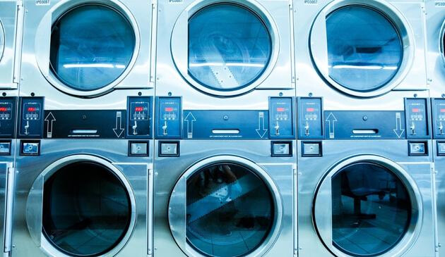 A picture of washing machine and tumble dryers in a laundrette.
