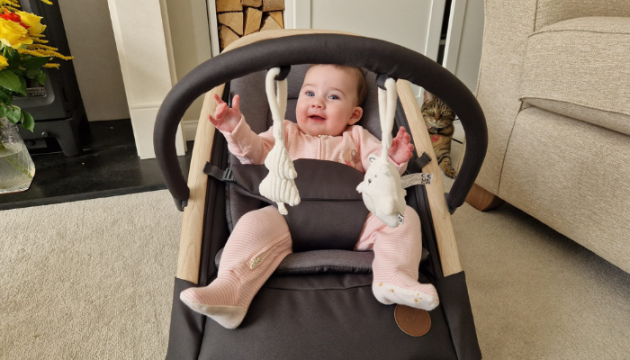 Baby playing with toy arch in the Maxi-Cosi Kori bouncer