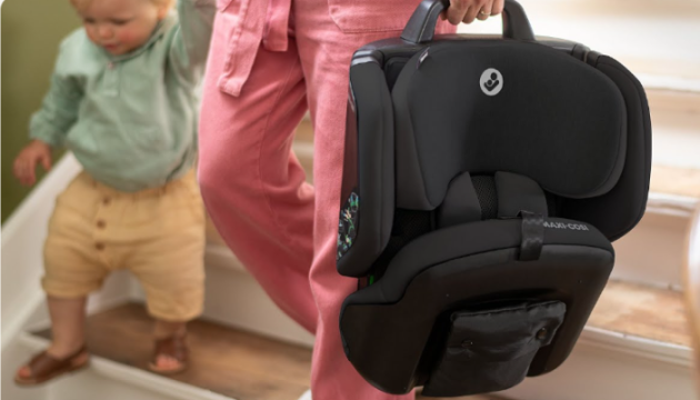 Mum carrying Maxi-Cosi Nomad Plus car seat