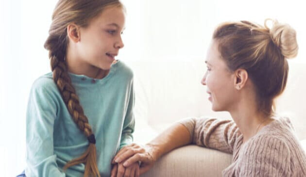 Preteen girl talking to older woman or mother