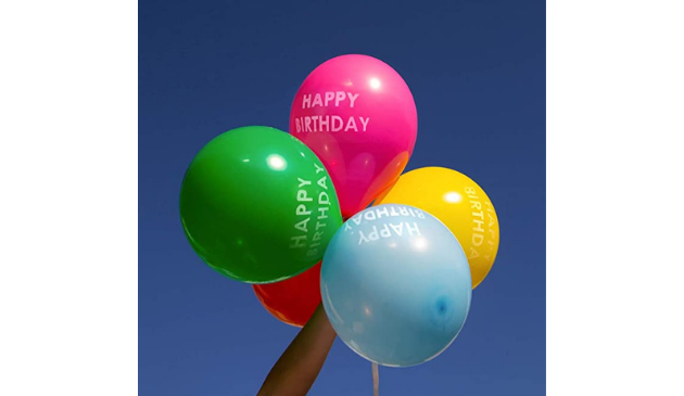 a hand holding up a bunch of multi coloured balloons against a blue sky