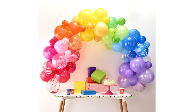 balloons in an arch shape over a table full of gifts
