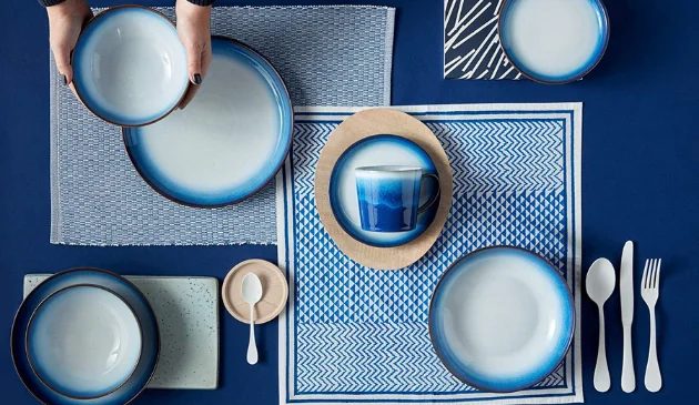 a table laid with blue Denby plates and silver cutlery