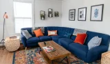 A living room with a blue corner sofa and colourful cushions