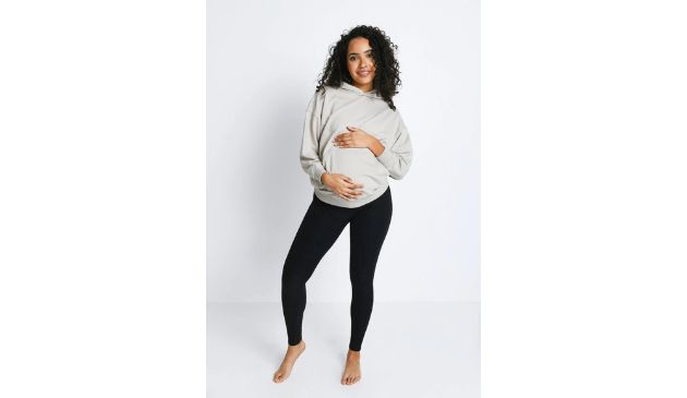 a pregnant woman wearing black leggings and a grey top