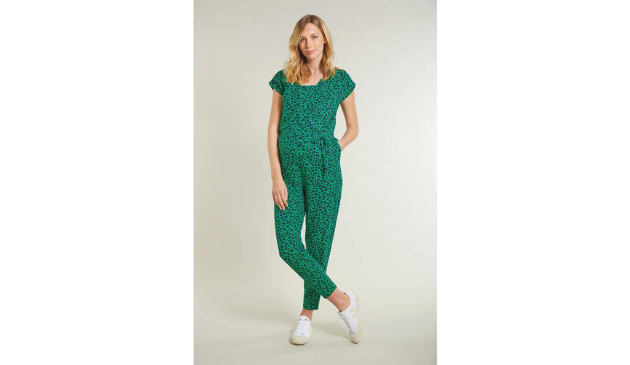 a pregnant woman posing in a green jumpsuit