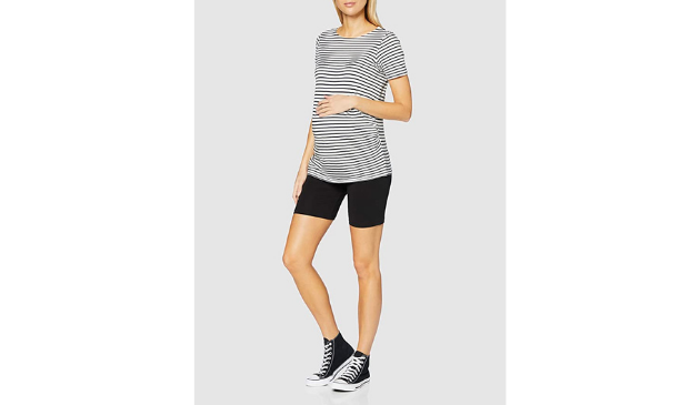 a pregnant woman posing in cycling shorts and a stripy top