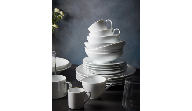 a stack of white dinner plates, bowls and cups